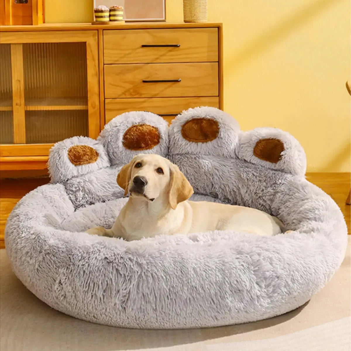 Dog relaxing on gray bedding with a cozy blanket.